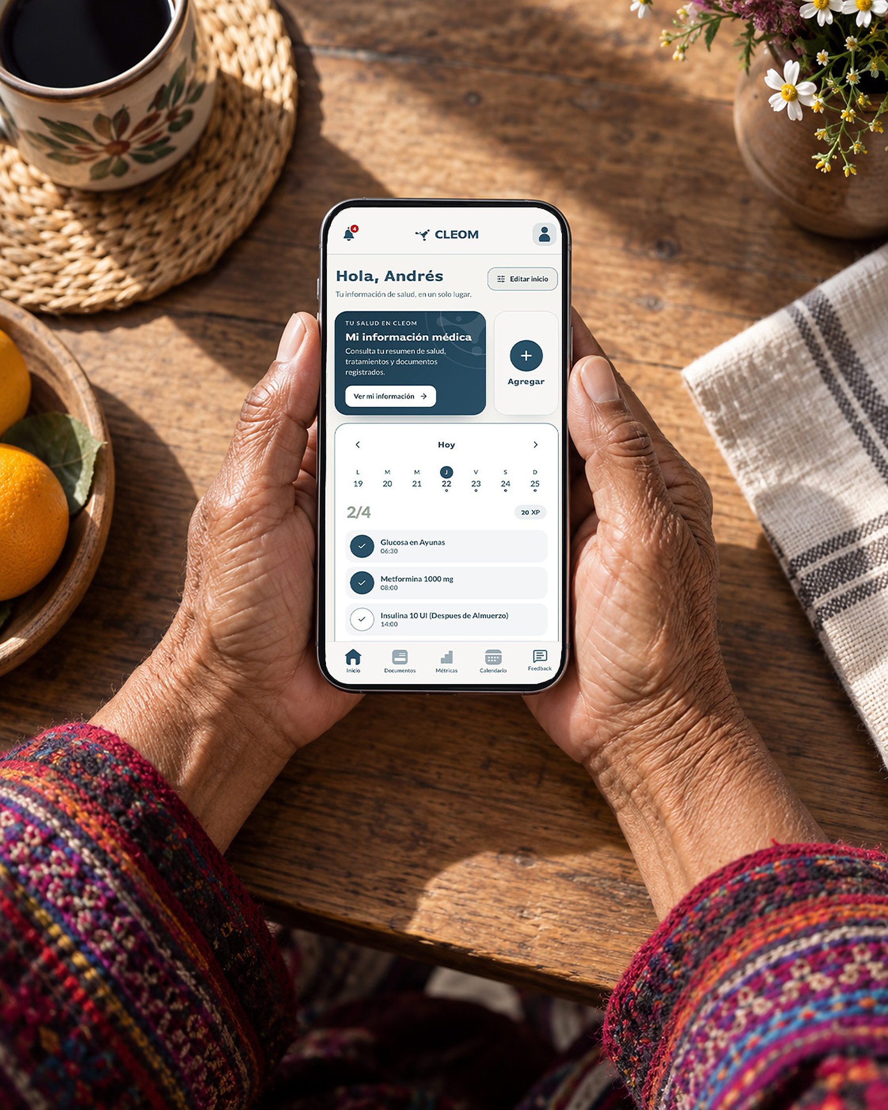 Manos de una persona mayor revisando la app Cleom en el teléfono